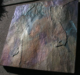 A piece of slate tile made to look like abalone shell by using a combination of pearls on it.